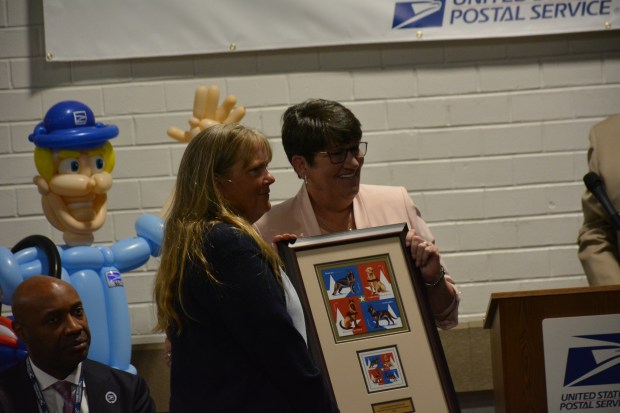 Tara Snyder, left, is presented with a gift by Linda DeCarlo, senior director, occupational safety and health for the United States Postal Service. (Richard Ilgenfritz - MediaNews Group)