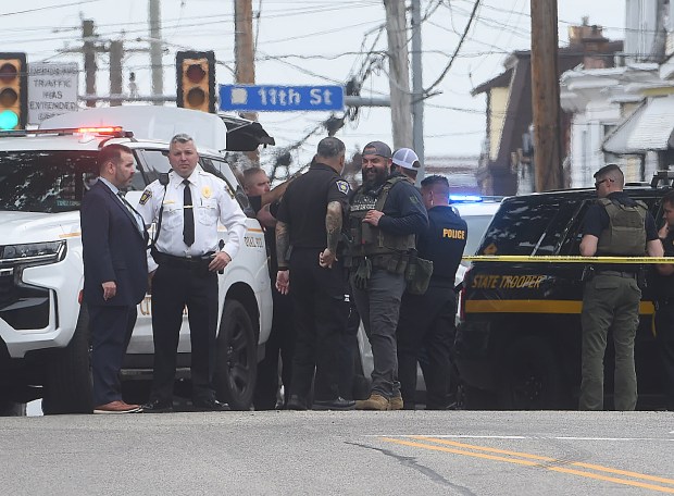 In the left of center, Delaware County chief of detectives James Nolan and Chester Police Commissioner Stephen Gretsky, white shirt. Also in the photo, at right is a Delaware state police vehicle. (PETE BANNAN-DAILY TIMES)