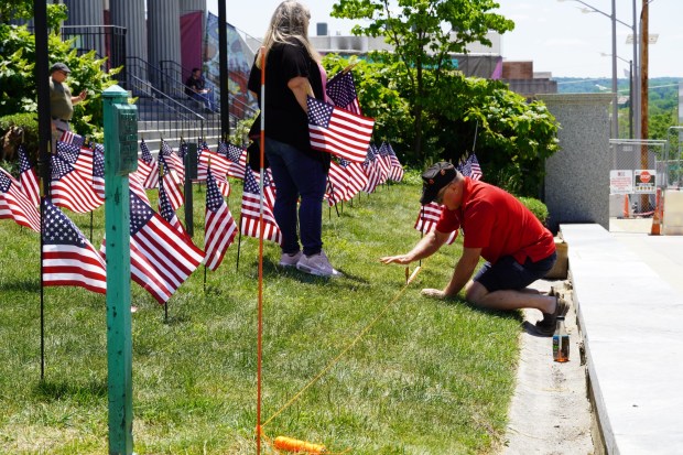 Volunteer Craig Bird works to make a space in the Montgomery County Courthouse lawn for an American flag on May 26, 2023. Seventy-five flags are being placed in downtown Norristown ahead of Memorial Day. (Photo courtesy Colin McGlinchey/Montgomery County, PA)