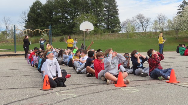 Students at Gwynedd Square Elementary School in Upper Gwynedd wear solar eclipse glasses provided by Merck to watch the solar eclipse on Monday, April 8 2024. (Dan Sokil - MediaNews Group)