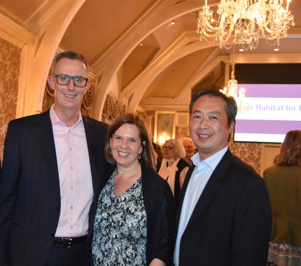 Stephen Perry, board chairman, Meredith Flower-Perry and Lam Chau, director of construction, enjoyed time at the Habitat for Humanity Fundraiser. (Photo by Maggie Corcoran)