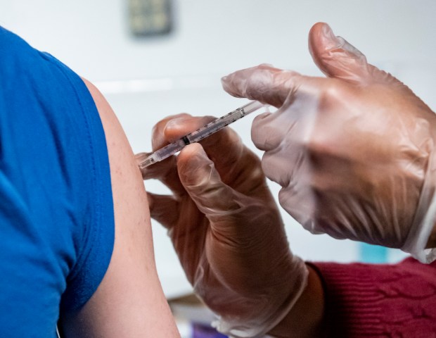 Hardik Parel a pharmacist at Vista Pharmacy, administers a does of Moderna COVID-19 vaccine to Michael Pinkerton, 13. During a COIVD-19 vaccine clinic held by AmeriHealth Caritas at Fantasy Skating Center in Muhlenberg, PA Monday afternoon Feb. 21, 2022 with the goal of getting more children ages 5 to 17 vaccinated. After getting vaccinated, children were given tickets for free roller skating as in incentive to get the vaccine. (READING EAGLE)