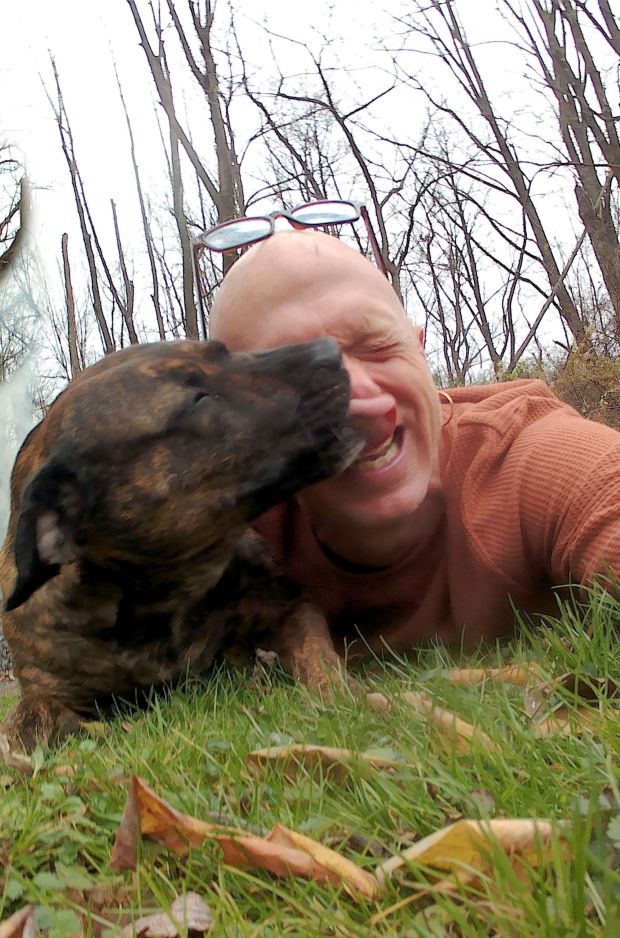 Gary Emes gets a kiss from his dog Bailey while stopping for a selfie during a walk on their Ruscombmanor Township property. Emes maintained his sobriety while recovering from hip replacement surgery on July 5, 2023. (Courtesy of Gary Emes)