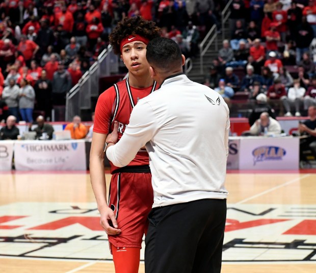 Reading High coach Rick Perez talks with Aris Rodriguez after he missed what could have been a game-clinching free throw in regulation against Roman Catholic in the Red Knights' 63-56 overtime win in the PIAA Class 6A Final Saturday in the Giant Center. (BILL UHRICH - READING EAGLE)