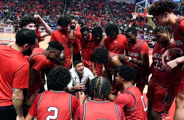 Reading High huddles with coach Rick Perez near the end of regulation in the Red Knights' 63-56 overtime win over Roman Catholic in the PIAA Class 6A Final Saturday in the Giant Center. (BILL UHRICH - READING EAGLE)