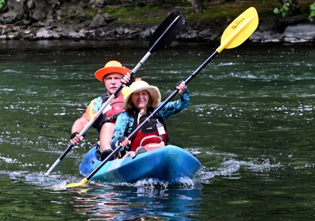 Man and woman paddling in a kayak in the river.